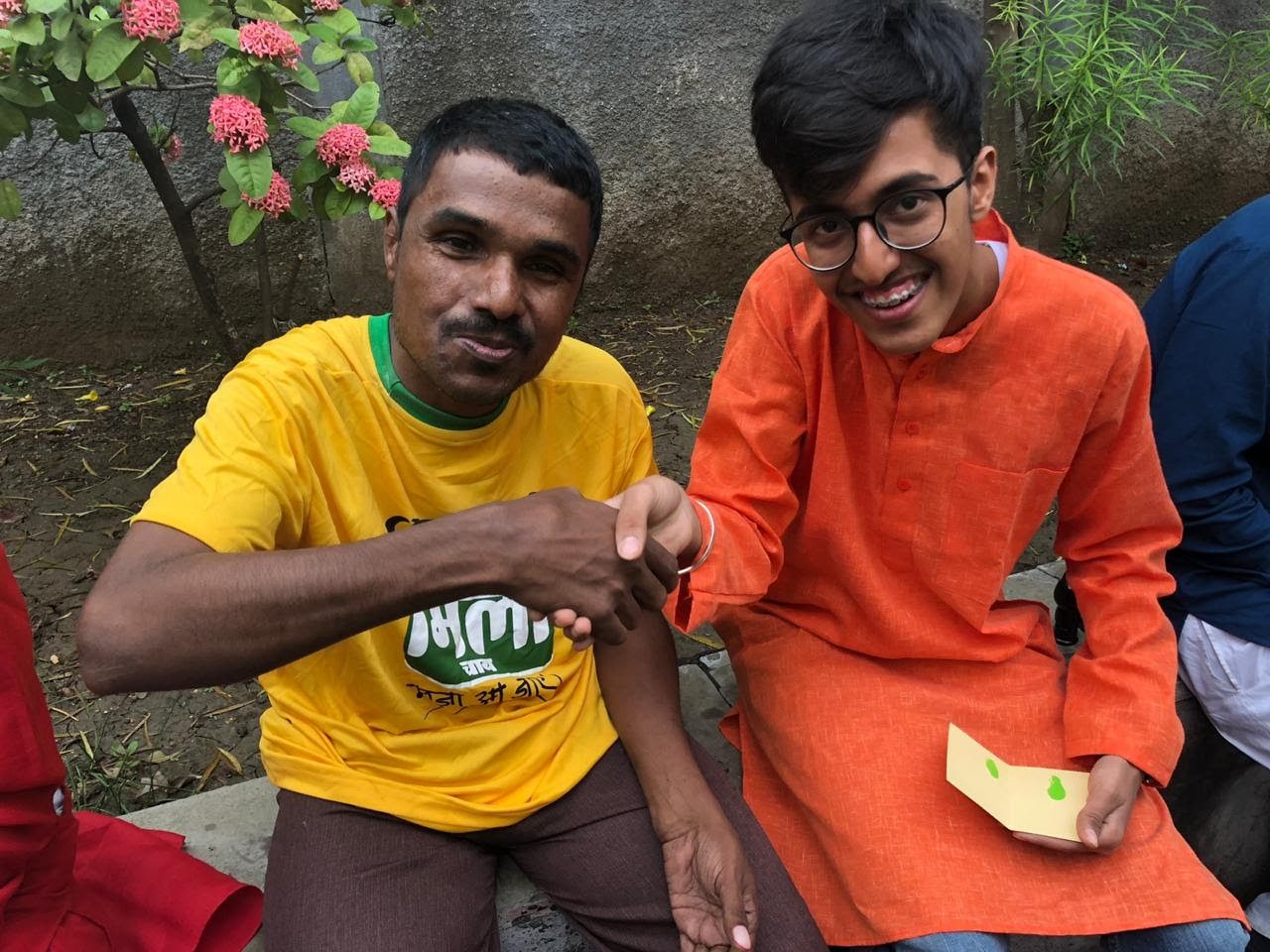 Volunteer greeting a man with a handshake