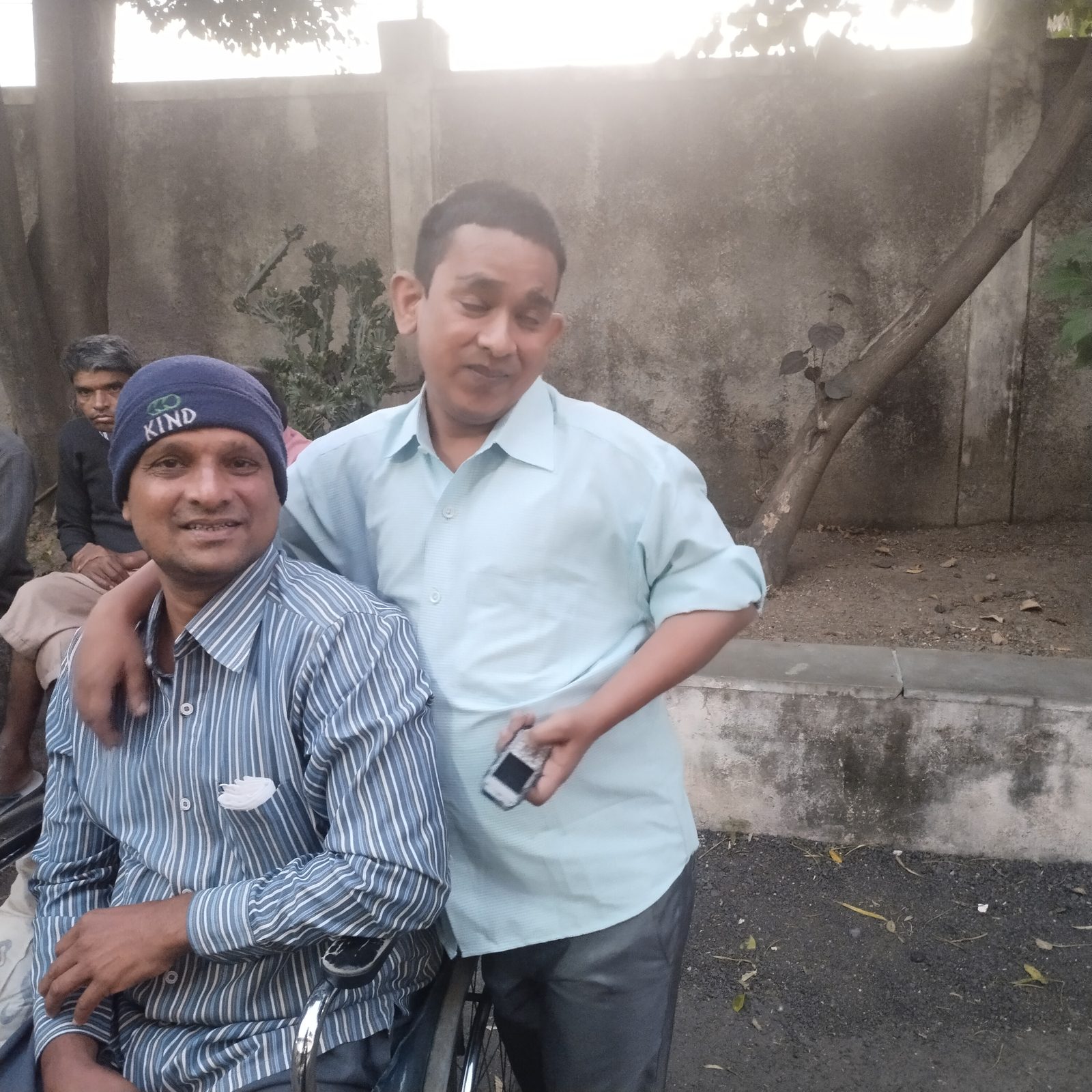 Police officer applying tilak on a volunteer's forehead with sweets